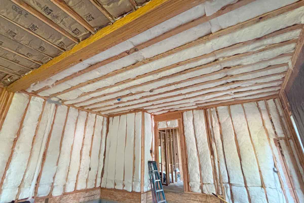 Closed-cell spray foam insulation applied to wall studs and ceiling joists in a single-family home in Brick, NJ, by Hudson Insulation.