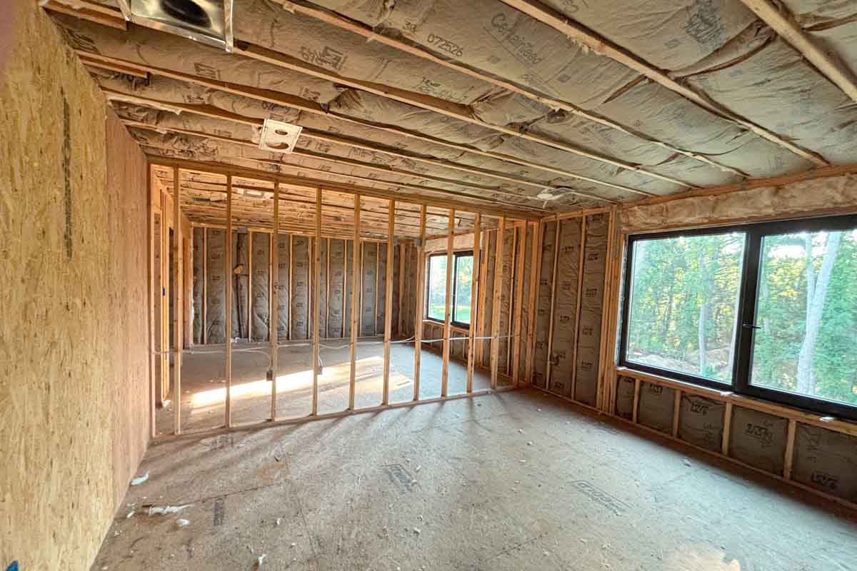 Fiberglass batt insulation in ceiling joists and exterior walls with open interior wall framing, single-family home in Brick, NJ, by Hudson Insulation.