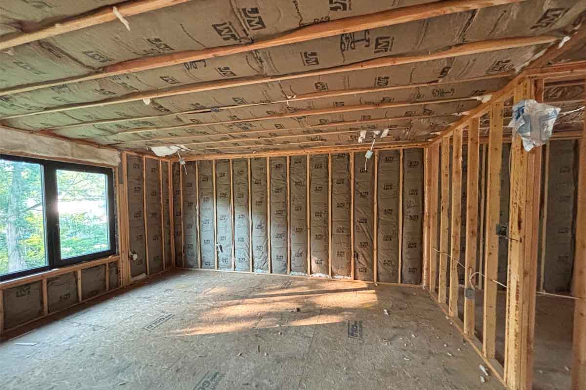 Services-Gallery-2 Fiberglass batt insulation installed in walls and vaulted ceiling with a large window, single-family home in Brick, NJ, by Hudson Insulation.