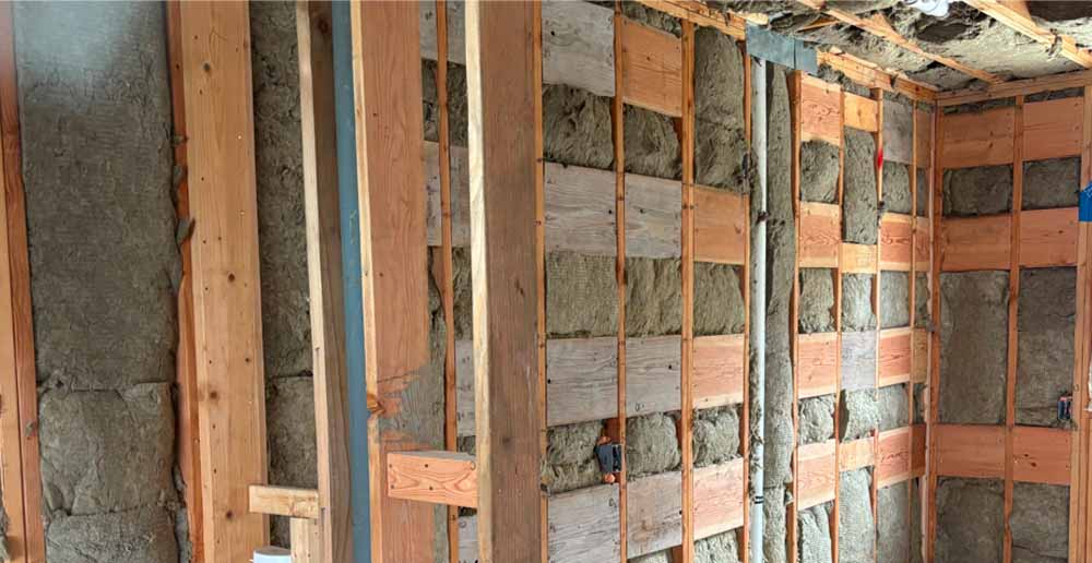 Full wall view of mineral wool insulation between studs with horizontal wood blocking, Point Pleasant, NJ.